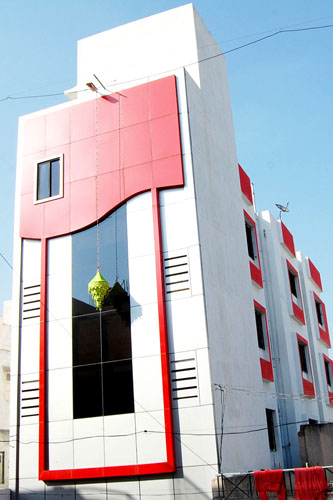 Hotel Saibansi building with a red and white glass facade